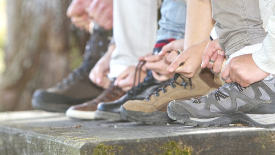family tying laces of hiking boots