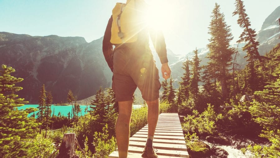 man with yellow hiking backpack in summer