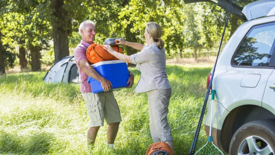 senior couple with blue camping cooler