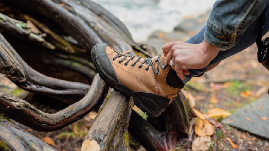 woman tying up the laces of her hiking boots outdoor