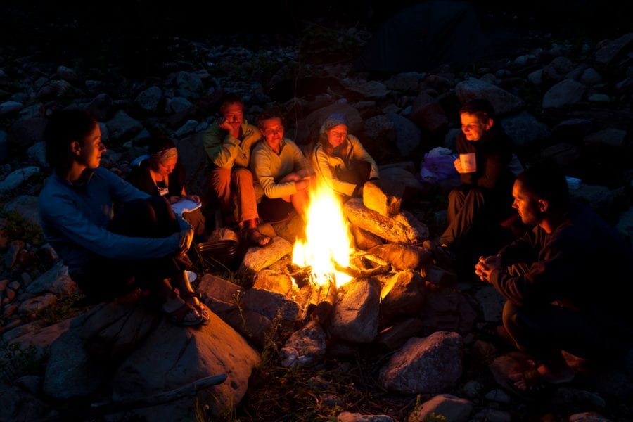Adults chatting around a campfire