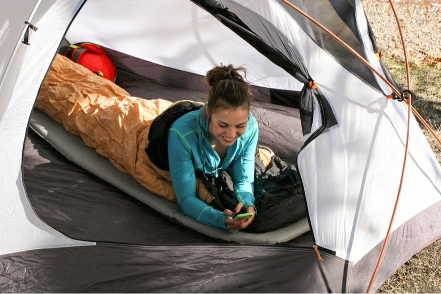 a woman tucked inside a warm sleeping bag and sleeping pad